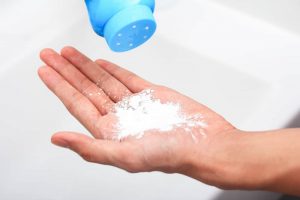 A man places talcum powder on his hands