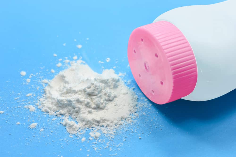 A bottle of talcum powder with a pink lid
