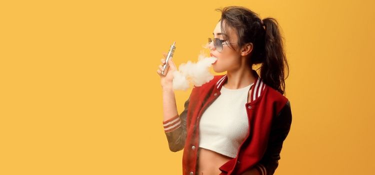 A young woman uses an electronic cigarette