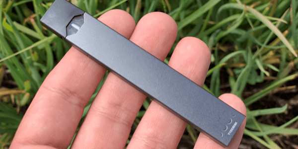 A gray JUUL brand vaporizer in a persons hand